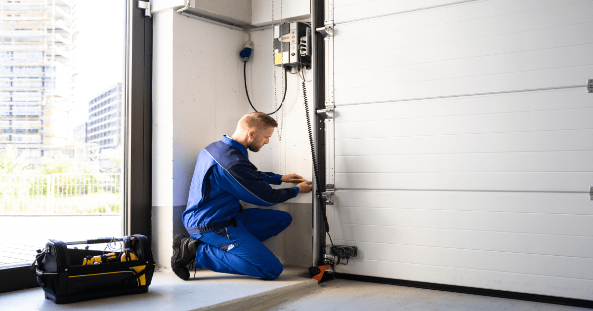 Vakman-installeert-pvc-garagepoort-met-scharnieren-en-zijaandrijving.png