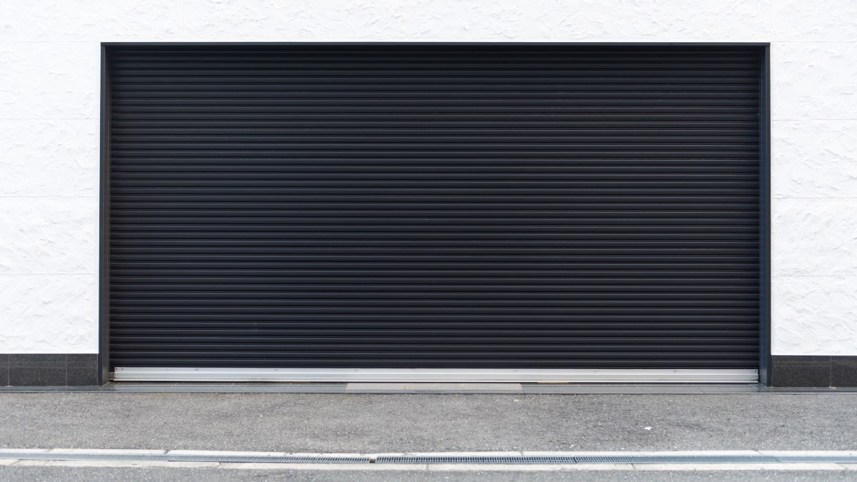 Zwarte garagepoort witte gevel.