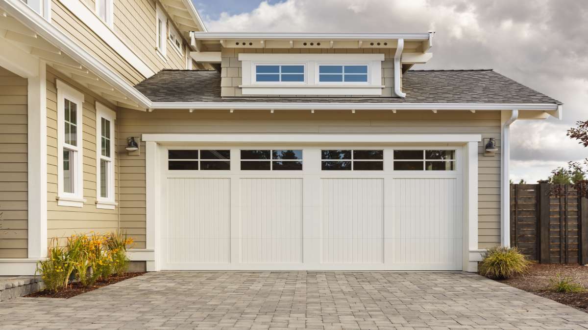 Witte garagepoort met ramen.