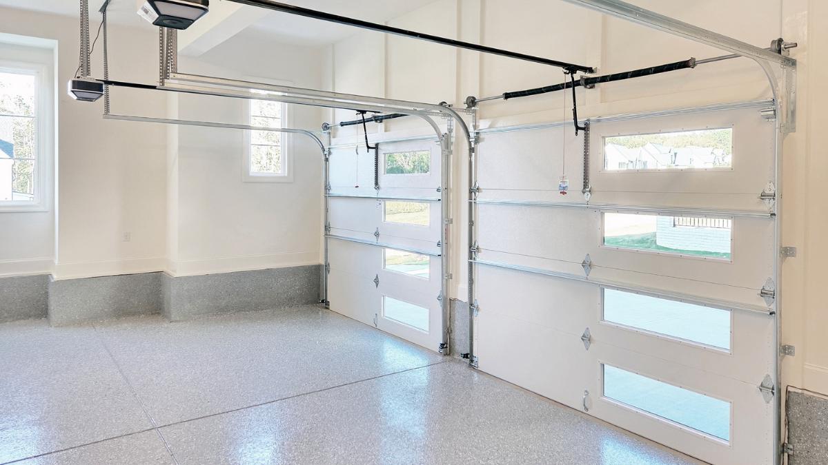 Witte dubbele garagepoort met ramen en veel lichtinval.