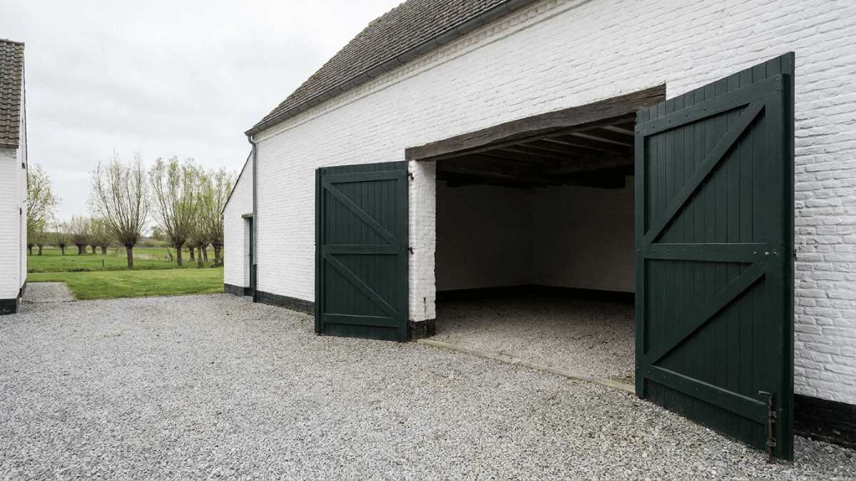 Groene openslaande garagepoort.